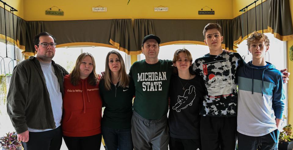 Tina Timm (third from left) and Adrian Blow (Michigan State shirt) with their children in their home in Okemos, Mich.