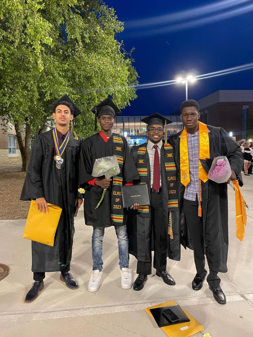 Mohammed Sanogo, far right, poses with some of his fellow graduates after Newark High School's ceremonies at the University of Delaware on June 15, 2023.