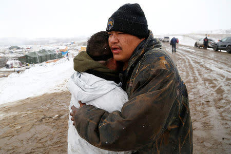 Opponents of the Dakota Access oil pipeline embrace as they prepare to evacuate the main opposition camp against the pipeline near Cannon Ball, North Dakota, U.S., February 22, 2017. REUTERS/Terray Sylvester