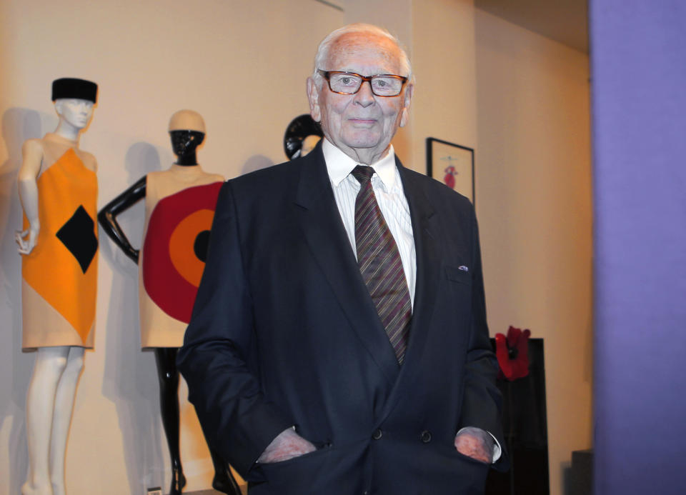 FILE - In this file photo dated Thursday, Nov. 13, 2014, French fashion designer Pierre Cardin poses backdropped by some of his designs during the inauguration of the Pierre Cardin Museum in Paris, France. France's Academy of Fine Arts said Tuesday Dec. 29, 2020, that famed fashion designer Pierre Cardin has died aged 98. (AP Photo/Jacques Brinon, FILE)