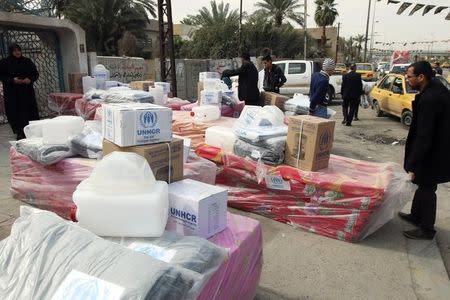 Displaced Iraqi Sunnis fleeing from Islamic State militants in al-Baghdadi district in Anbar provinces, receive aid from the United Nations Refugee Agency (UNHCR) in Baghdad February 24, 2015. REUTERS/Thaier Al-Sudani