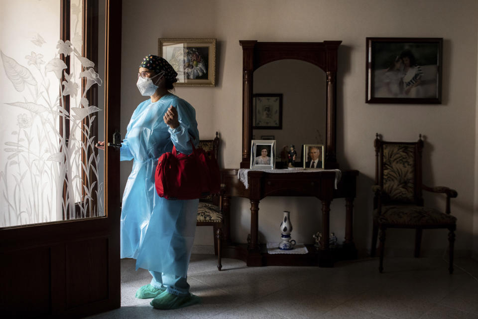 Nurse Pilar Rodríguez leaves the house of her patient Antonia Crespi, 93, in the town of Sa Pobla on the Spanish Balearic Island of Mallorca, Spain, Friday, April 30, 2021. (AP Photo/Francisco Ubilla)