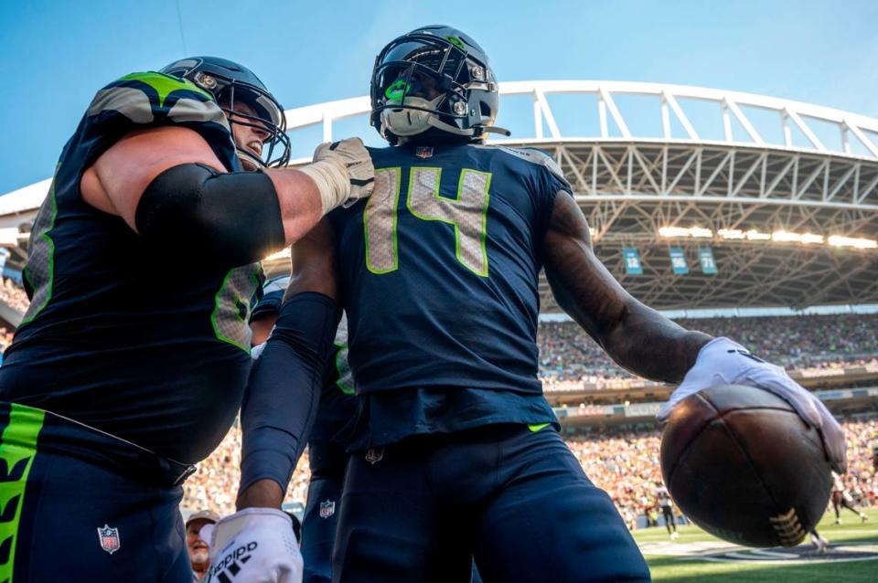 After catching a touchdown pass from quarterback Geno Smith (7), Seattle Seahawks wide receiver DK Metcalf (14) celebrates with guard Austin Blythe (63) during the second quarter of an NFL game on Sunday, Sept. 25, 2022, at Lumen Field in Seattle.