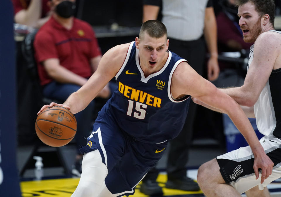 Denver Nuggets center Nikola Jokic, left, drives past San Antonio Spurs center Jakob Poeltl in the second half of an NBA basketball game Friday, April 9, 2021, in Denver. (AP Photo/David Zalubowski)