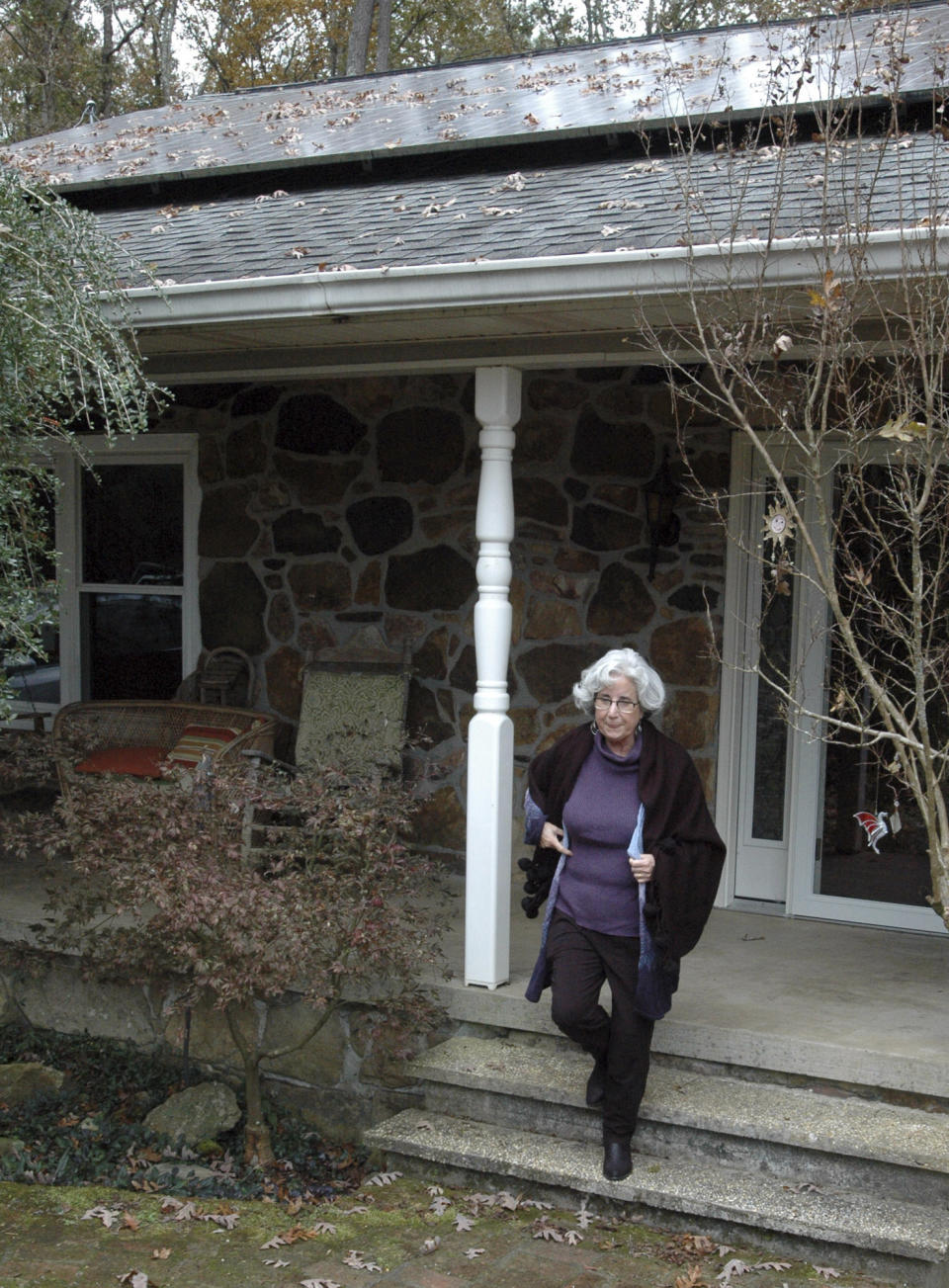 FILE - In this Thursday, Nov. 14, 2019 file photo, Teresa Thorne walks out of her solar power-equipped home near Springville, Ala. The fees imposed by the Alabama Power company on customers who generate their own electricity with rooftop or on-site solar panels are now the subject of a federal lawsuit against the state's regulators. Environmental groups argue that punishing fees are purposely discouraging the adoption of solar power in the sun-rich state. (AP Photo/Jay Reeves, File)