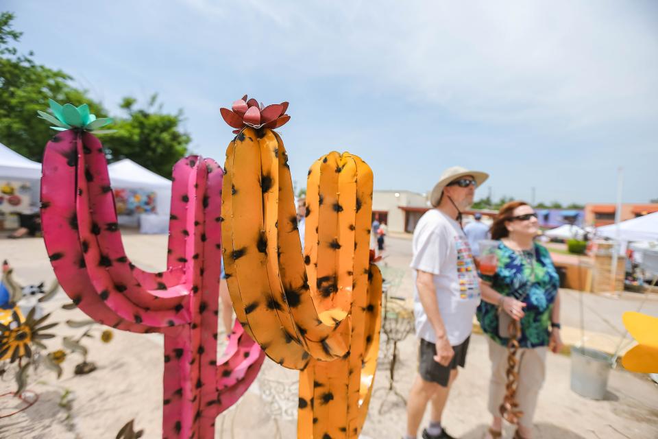 Two saguaro cacti made of metal sit in Veva Womack's All About Metal shop at the 2022 Paseo Art Festival in Oklahoma City.