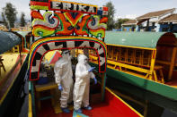 Doctors in protective suits call for the next person in line to board a trajinera for COVID-19 testing in the Xochimilco district of Mexico City, Thursday, Sept. 10, 2020. The borough's health department has begun a campaign to test gondoliers, vendors, and dock workers for coronavirus every few weeks, in a bid to reassure tourists that it is safe to return to Xochimilco's iconic canals.(AP Photo/Rebecca Blackwell)