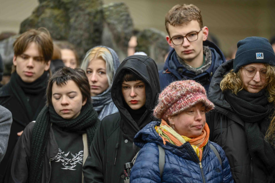 Mourners stand outside the headquarters of Charles University after mass shooting in Prague, Czech Republic, Friday, Dec. 22, 2023. A lone gunman opened fire at a university on Thursday, killing more than a dozen people and injuring scores of people. (AP Photo/Denes Erdos)