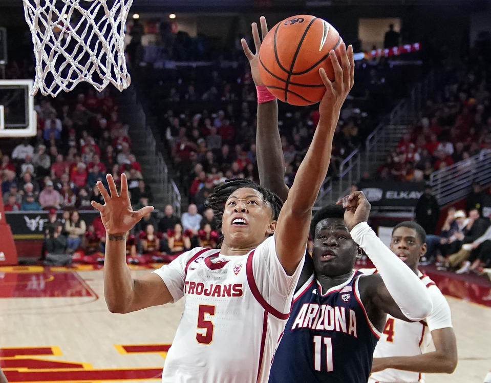 FILE - Southern California guard Boogie Ellis (5) shoots as Arizona center Oumar Ballo (11) defends during the first half of an NCAA college basketball game March 2, 2023, in Los Angeles. The Pac-12 enters what could be its final basketball season with depth from top to bottom, including No. 12 Arizona, No. 21 Southern California and UCLA. (AP Photo/Mark J. Terrill, File)