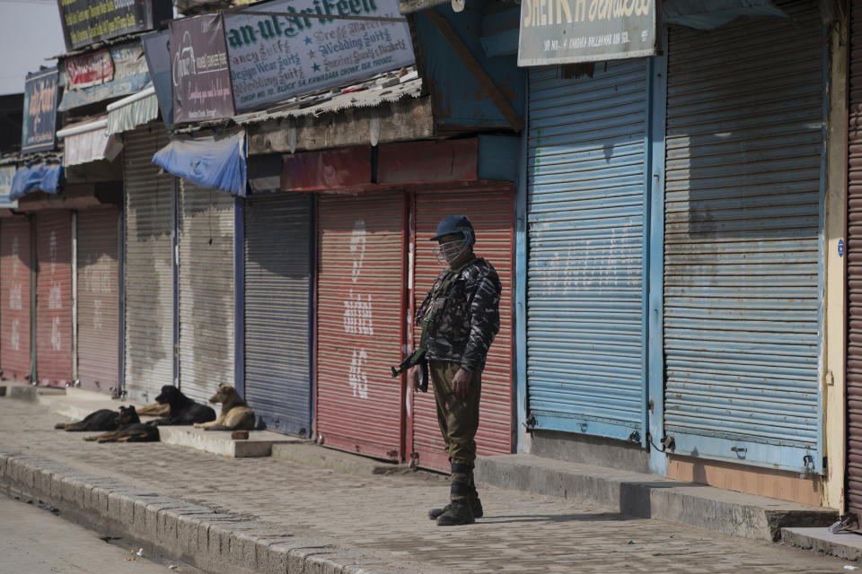 An Indian paramilitary soldier stands guard outside a closed market during security lockdown in Srinagar, Indian controlled Kashmir, Sunday, Feb. 24, 2019. Shops and businesses have closed in Kashmir to protest a sweeping crackdown against activists seeking the end of Indian rule in the disputed region. (AP Photo/ Dar Yasin)