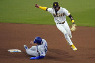 San Diego Padres shortstop Fernando Tatis Jr., right, goes over the top of Los Angeles Dodgers' Max Muncy, as Muncy slides in safely to second base during the 12th inning of a baseball game Friday, April 16, 2021, in San Diego. Los Angeles Dodgers' Chris Taylor grounded into a fielders choice, and Tatis picked up a fielding error on the play. (AP Photo/Gregory Bull)