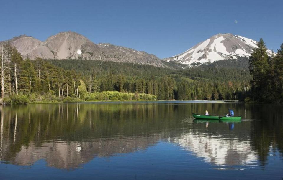 Chaos Crags, top left, and Lassen Peak (with snow) loom over boaters on Manzanita Lake in Lassen Volcanic National Park in July 2006.