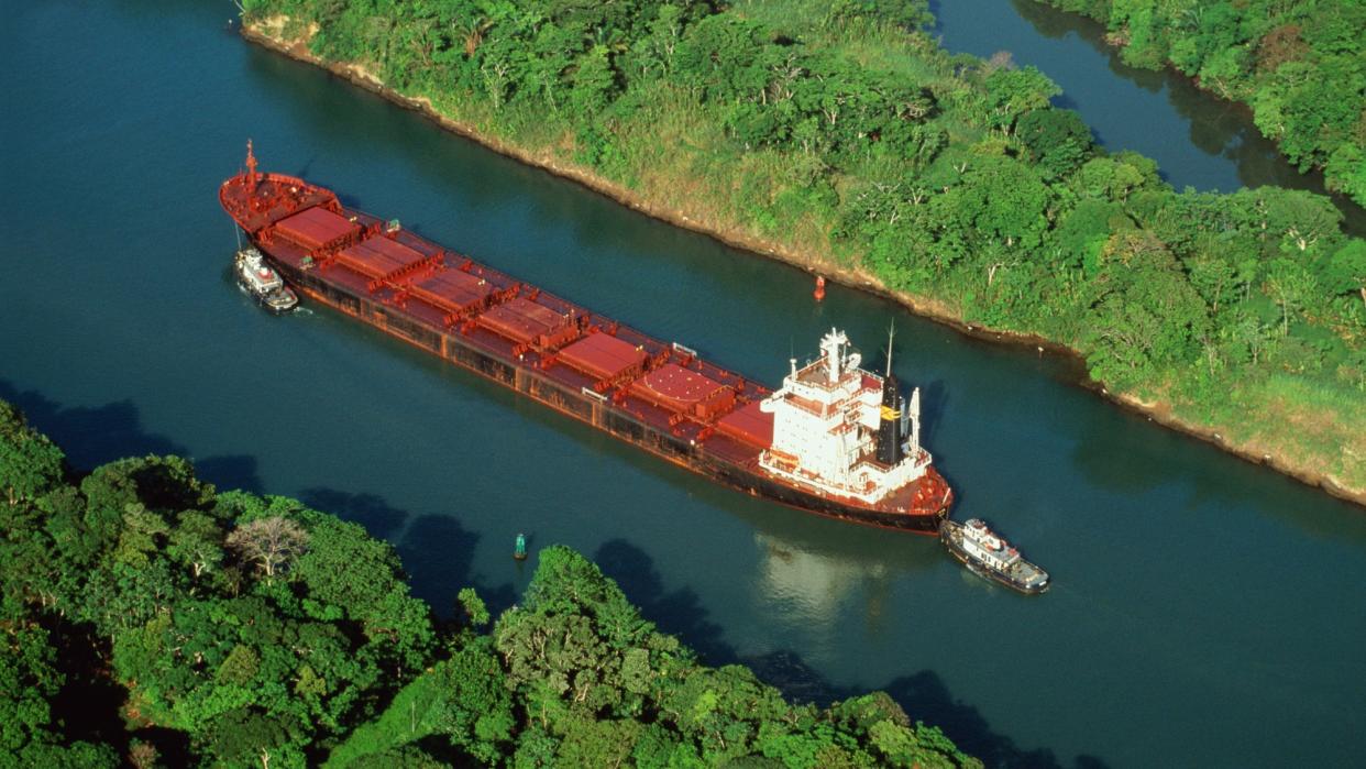  Tugs guiding cargo ship through Panama Canal. 
