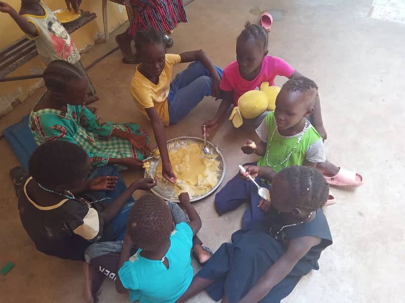 Refugees eat food at "Dar Mariam" a Catholic church and school compound in al-Shajara district, where they took shelter, in Khartoum