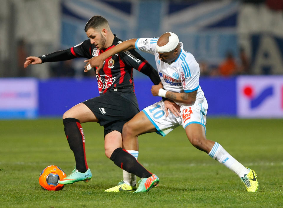 Marseille's Ghanaian forward Andre Ayew, right, challenges for the ball with Nice's French midfielder Valentin Eysseric , during their League One soccer match, at the Velodrome Stadium, in Marseille, southern France, Friday, March 7, 2014. (AP Photo/Claude Paris)