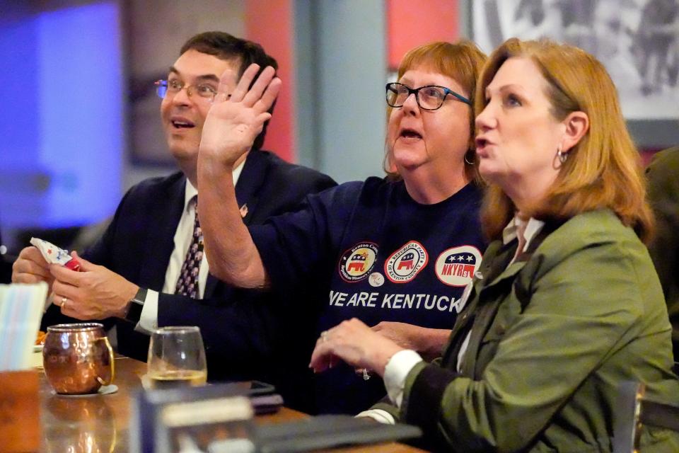 Kathleen Bell, middle, a Vice President of Kenton County Republican Women’s Club, waves at the television screen at The Globe cocktail bar in Covington as Kentucky’s next Attorney General Russell Coleman gives a victory speech.