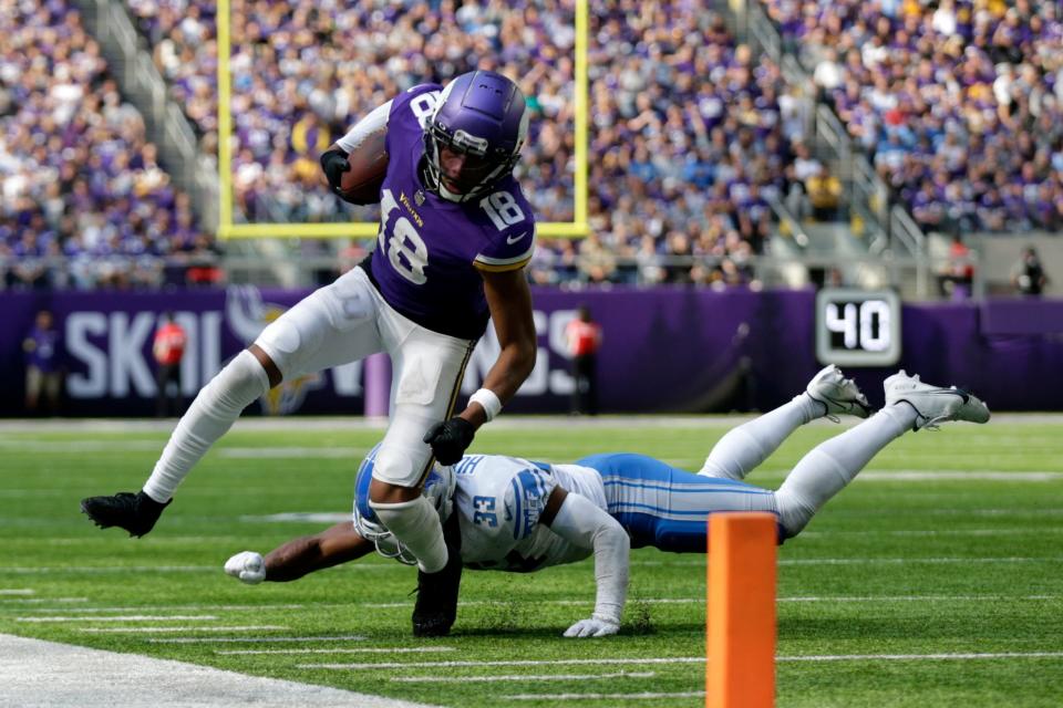 Vikings wide receiver Justin Jefferson (18) runs from Lions safety JuJu Hughes after catching a pass during the second half, Sunday, Sept. 25, 2022, in Minneapolis.