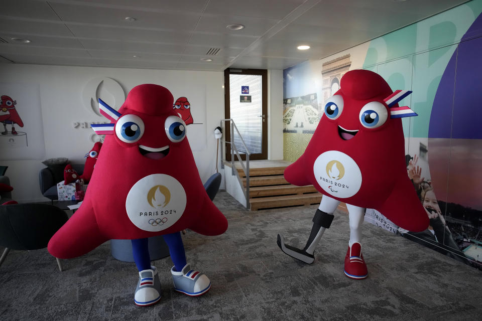 Mascots of the 2024 Paris Olympic Games, left, and Paralympics Games, a Phrygian cap, pose during a preview in Saint Denis, outside Paris, Thursday, Nov. 10, 2022. The soft bright red cap, also known as a liberty cap, is an updated version of a conical hat worn in antiquity in places such as Persia, the Balkans, Thrace, Dacia and Phrygia, where the name originates, in modern day Turkey. It later became a symbol of the pursuit of liberty in the French Revolution and is still worn by the figure of Marianne, the national personification of France since that time. (AP Photo/Christophe Ena)