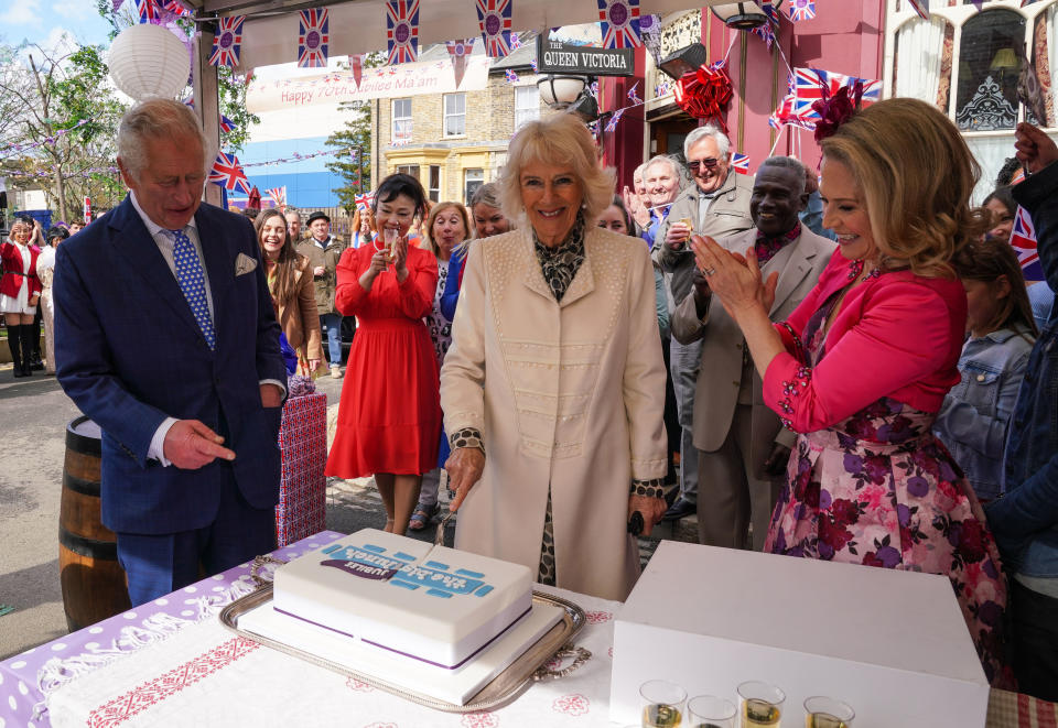 Camilla cuts a celebration cake on the EastEnders visit. (BBC)