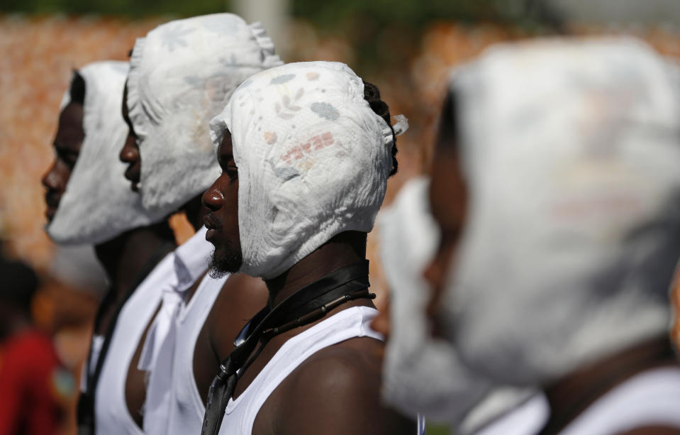 Performers wear diapers on their heads during a march led by the art community to continue demanding the resignation of Haitian President Jovenel Moise in Port-au-Prince, Haiti, Sunday, Oct. 13, 2019. Protests have paralyzed the country for nearly a month, shuttering businesses and schools. (AP Photo/Rebecca Blackwell)