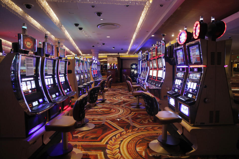 Chairs have been removed at some electronic slot machines to maintain social distancing between players at a closed Caesars Palace hotel and casino Thursday, May 21, 2020, in Las Vegas. Casino operators in Las Vegas are awaiting word when they will be able to reopen after a shutdown during the coronavirus outbreak. (AP Photo/John Locher)