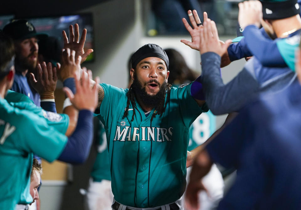 Seattle Mariners' J.P. Crawford is congratulated in the dugout after scoring against the Los Angeles Angels during the fourth inning of a baseball game Tuesday, Sept. 12, 2023, in Seattle. (AP Photo/Lindsey Wasson)