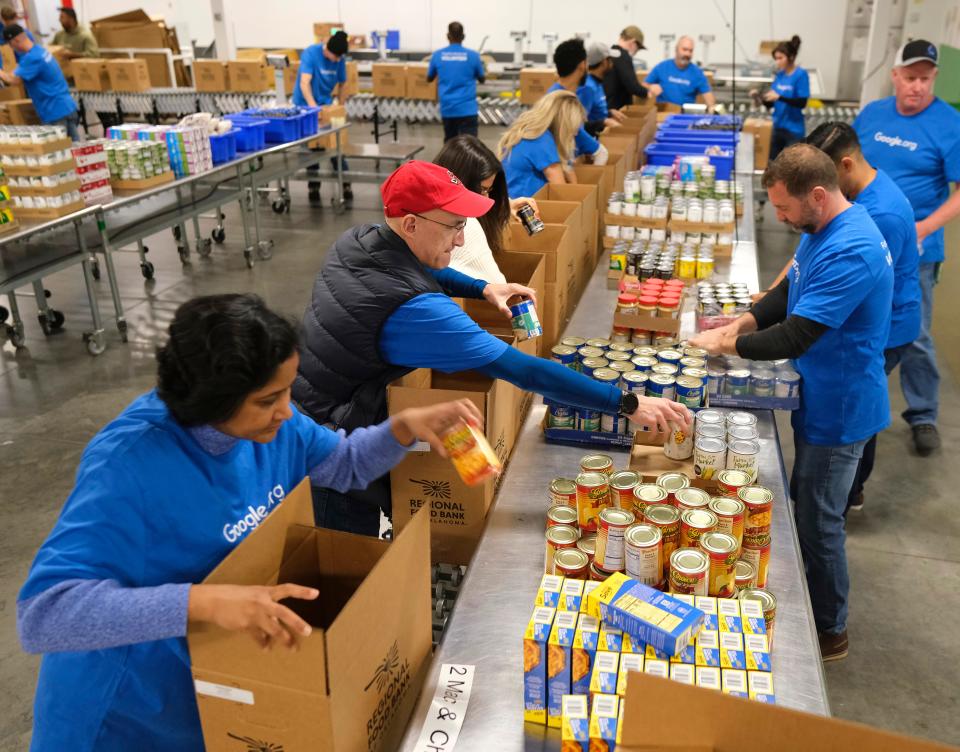 Google representatives help package and box donated food Monday at the Regional Food Bank of Oklahoma Volunteer Center.