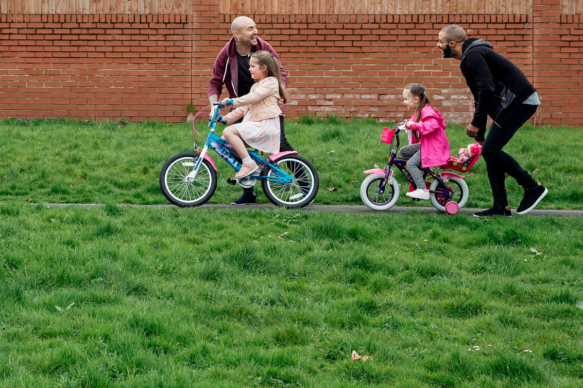 A couple take their children out to ride their bicycles. 