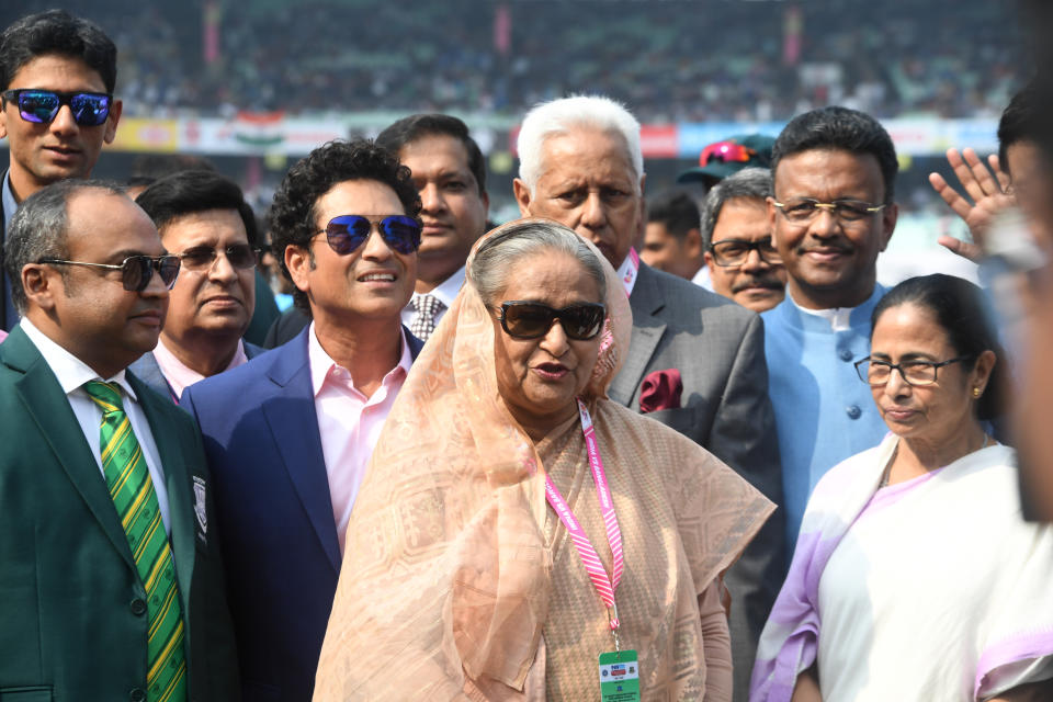 Bangladesh's Prime Minister Sheikh Hasina (C) speaks as West Bengal Chief Minister Mamata Banerjee (R) and former Indian cricketer Sachin Tendulkar (4th L) watch before the start of the first day of the second Test cricket match of a two-match series between India and Bangladesh at The Eden Gardens cricket stadium in Kolkata on November 22, 2019. (Photo by Dibyangshu SARKAR / AFP) / IMAGE RESTRICTED TO EDITORIAL USE - STRICTLY NO COMMERCIAL USE