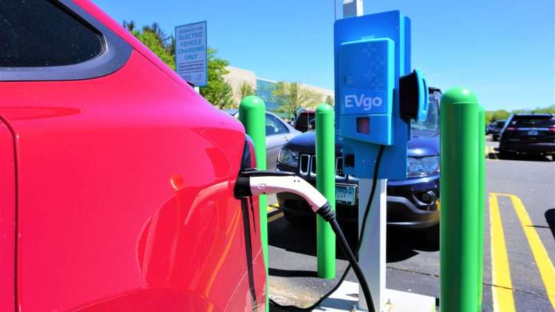 Multiple electric vehicles plugged in at an EVgo charging station.