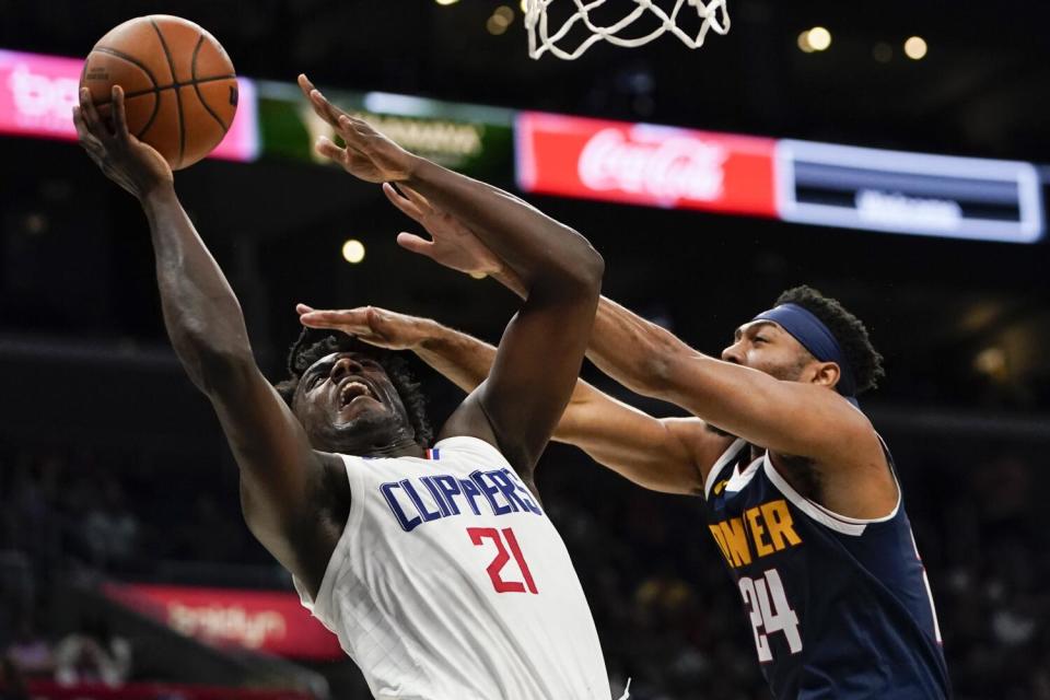 Clippers forward Kobe Brown tries to score in the lane while defended by Nuggets forward Jamorko Pickett.