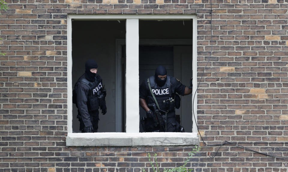Authorities search an abandoned building for a man who escaped a courthouse in Detroit, Monday, Sept. 9, 2013. Derreck White, 25, who police said also used the name Abraham Pearson, was awaiting sentencing in an armed robbery and escaped a Detroit courthouse on Monday after stabbing a sheriff's deputy several times in the neck and carjacking a motorist. The escape prompted a lockdown of the facility and sparked a manhunt. (Paul Sancya/AP)