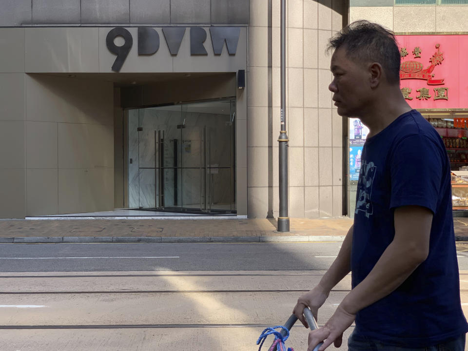 A worker walks past a building listed as the address of China Innovation Investment Limited in Hong Kong, Saturday, Nov. 23, 2019. Australia’s Treasurer on Saturday labeled detailed accusations of China infiltrating and disrupting democratic systems in Australia, Hong Kong and Taiwan as “very disturbing”. A Chinese defector revealed he was part of the Hong Kong-based investment firm, which was a front for the Chinese government to conduct political and economic espionage in Hong Kong, including infiltrating universities and directing bashings and cyber attacks against dissidents. (AP Photo/Ng Han Guan)