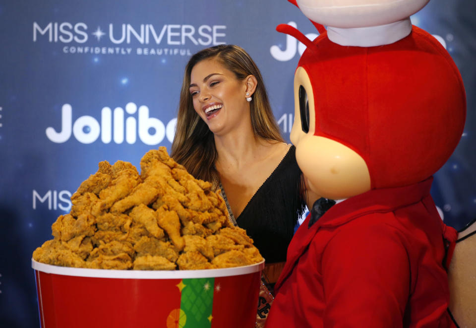 Miss Universe 2017 Demi-Leigh Nel-Peters of South Africa poses with a bucket of fried chicken during her interaction with Filipino orphans in her visit to the country’s fast food chain Jollibee, along with other Miss Universe winners on 7 December, 2017, in suburban Pasay city south of Manila, Philippines. (AP file photo)