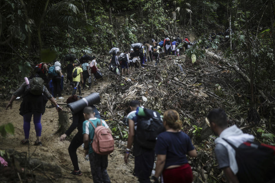 En esta imagen de archivo, migrantes cruzan a pie la selva del Darién desde Colombia a Panamá, con la esperanza de llegar a Estados Unidos, el 9 de mayo de 2023. El aumento de migrantes que van desde Colombia a Estados Unidos, a través de la selva del Darién hasta Panamá, alcanza una escala industrial que podría rondar las 500.000 personas este año. (AP Foto/Iván Valencia, archivo)