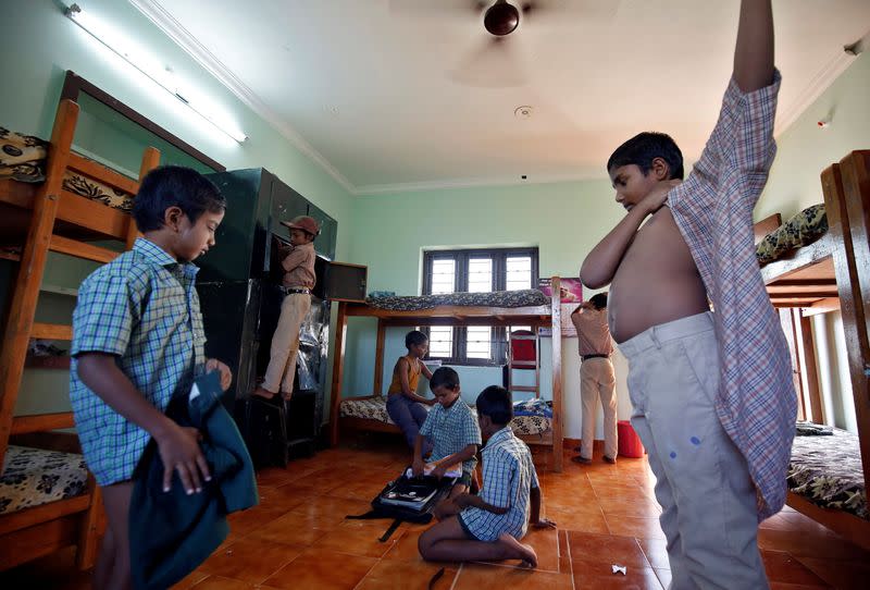 Boys staying in the care home set up by Karibeeran Paramesvaran and his wife Choodamani after they lost three children in the 2004 tsunami, put on their clothes before heading to school in Nagapattinam district in the southern state of Tamil Nadu, India