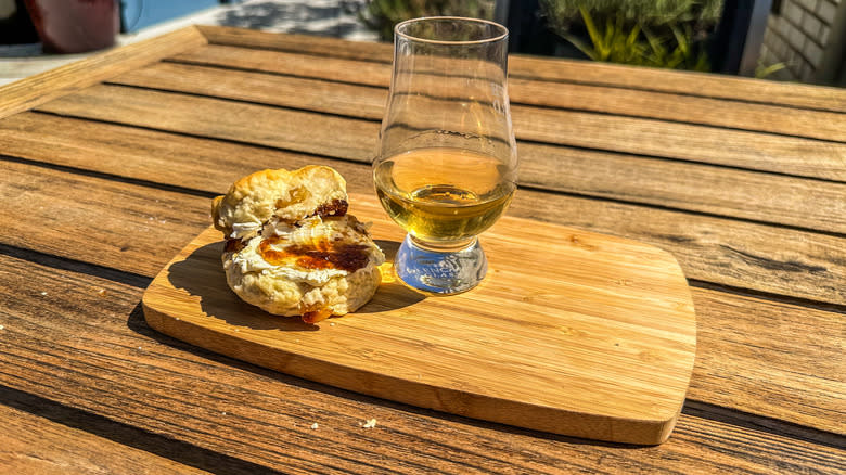 glass of whisky with a scone