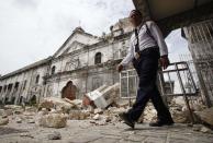 A security guard walks past the bell tower church of historic Basilica Minore of Sto Nino that fell down after an earthquake hit Cebu city, central Philippines October 15, 2013. City. At least six people were killed when buildings collapsed on islands popular with tourists in the central Philippines on Tuesday, radio reports said, after an earthquake measuring 7.2 hit the region. REUTERS/Stringer (PHILIPPINES - Tags: DISASTER ENVIRONMENT RELIGION)