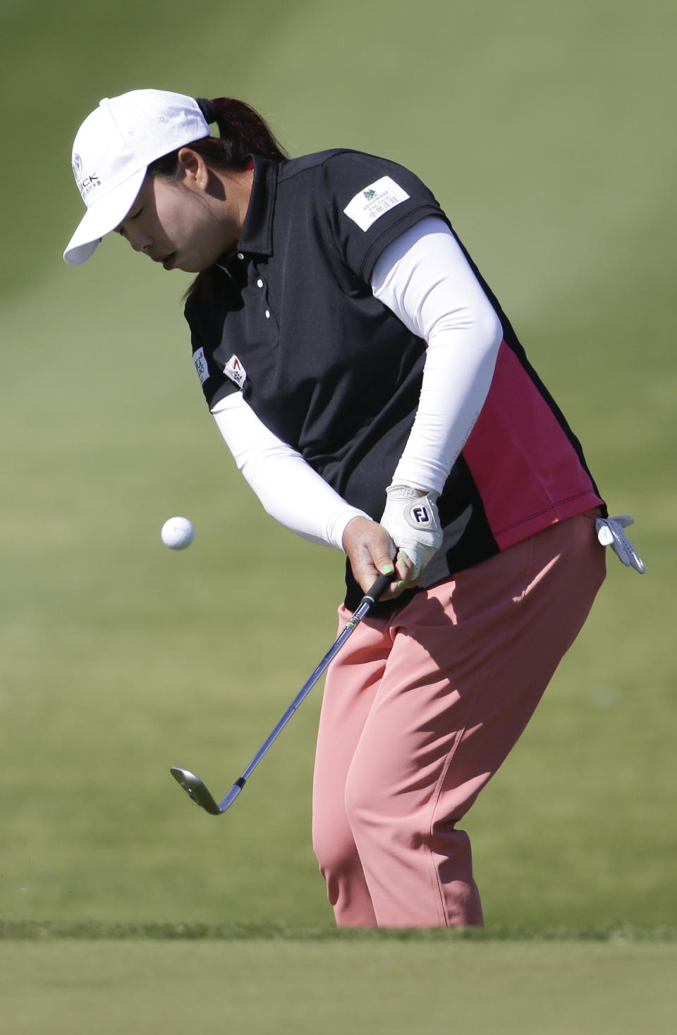 Shanshan Feng, of China, chips to the green on the ninth hole during the first round at the LPGA Kraft Nabisco Championship golf tournament Thursday, April 3, 2014 in Rancho Mirage, Calif. (AP Photo/Chris Carlson)