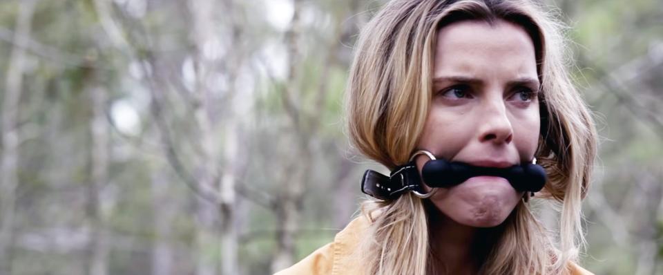 Betty Gilpin with her mouth gagged