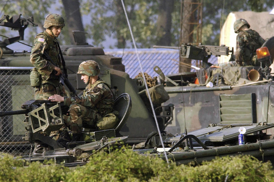 FILE - In this Oct. 6, 2004, file photo, U.S. Army soldiers stand guard on the armored vehicles at the their base in Dongducheon, South Korea. A U.S. military base in South Korea accidentally blared an alert siren instead of a bugle call, causing a brief scare just as the U.S. and its allies are monitoring for signs of a provocation from North Korea, which has warned it could send a "Christmas gift" over deadlocked nuclear negotiations. (AP Photo/Ahn Young-joon, File)