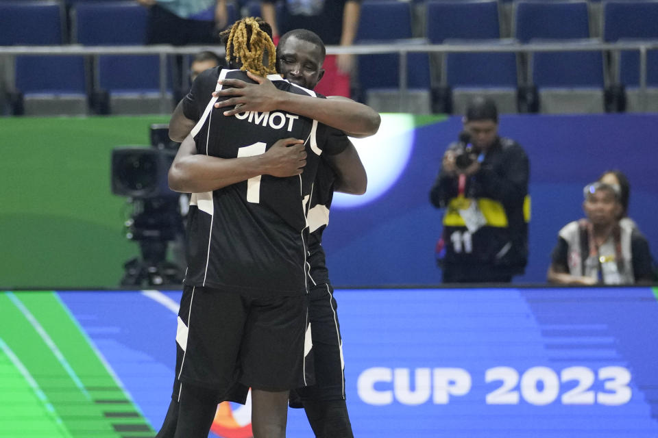 FILE - South Sudan players Nuni Omot (1) and Kuany Ngor Kuany (8) celebrate the team's win against China during a Basketball World Cup group B match at the Araneta Coliseum in Manila, Philippines, Aug. 28, 2023. Luol Deng used millions of his own dollars to fund the team in the first two years. The team's leaders tapped into a stable of players with ties to the country who were playing around the world, including former NBA G-League MVP Carlik Jones and others with NBA experience like Wenyen Gabriel, Omot and Blair alum Marial Shayok. (AP Photo/Aaron Favila, File)