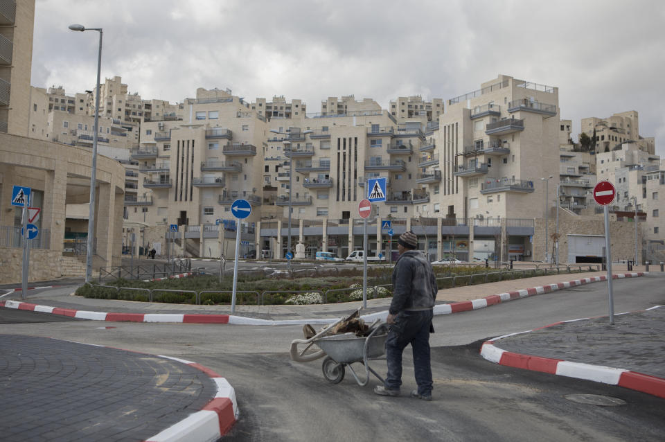 This photo taken Tuesday Feb. 14, 2017, shows a construction worker in Har Homa neighborhood in east Jerusalem. For many Israelis, Har Homa has become another neighborhood in Jerusalem, served by city bus lines, schools and public services. Its quiet streets are lined with apartment buildings, pizza shops, supermarkets and pharmacies. But for the Palestinians, this unassuming neighborhood is far more. It is an illegal settlement in east Jerusalem, and in some ways, the most damaging. (AP Photo/Dan Balilty)