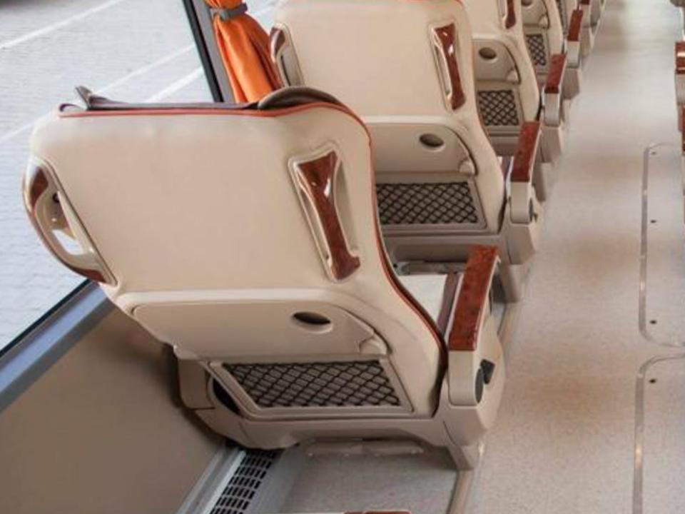 Inside the bus to London. The seats are beige and white.