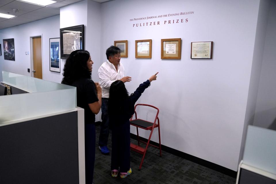 On a newsroom tour, Executive Editor David Ng shows Meera and her mom the citations for the four Pulitzer Prizes won by The Providence Journal.