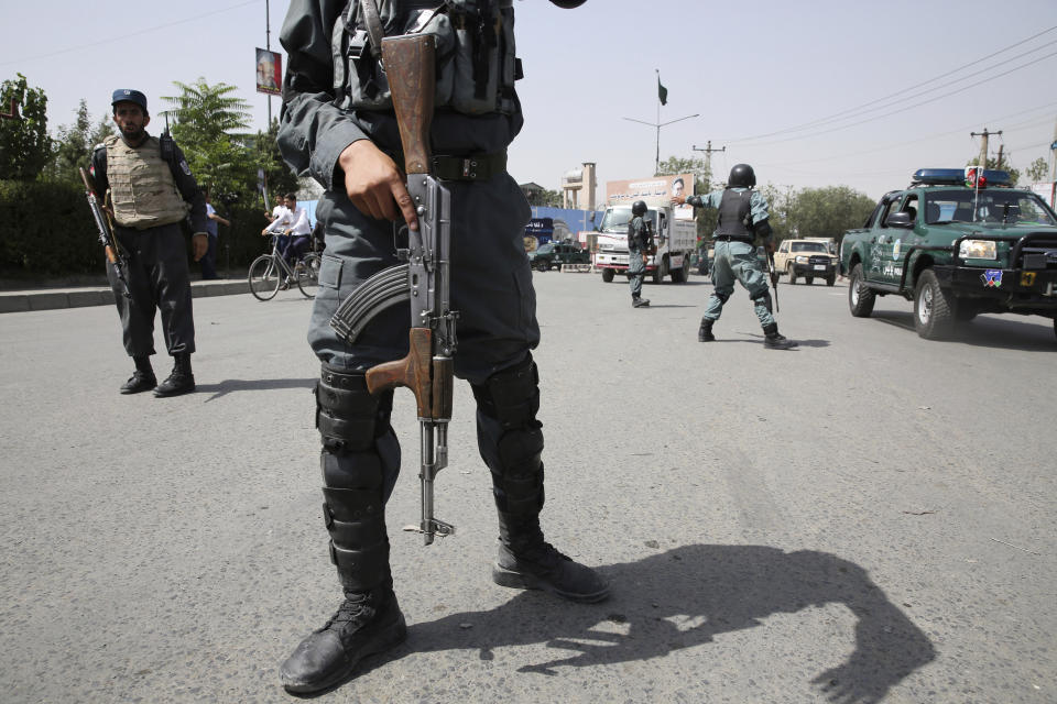 An Afghan policemen stand guard after an explosion near the police headquarters in Kabul, Afghanistan, Wednesday, Aug. 7, 2019. A suicide car bomber targeted the police headquarters in a minority Shiite neighborhood in western Kabul on Wednesday, setting off a huge explosion that wounded dozens of people, Afghan officials said. The Taliban claimed responsibility for the bombing. (AP Photo/Rafiq Maqbool)