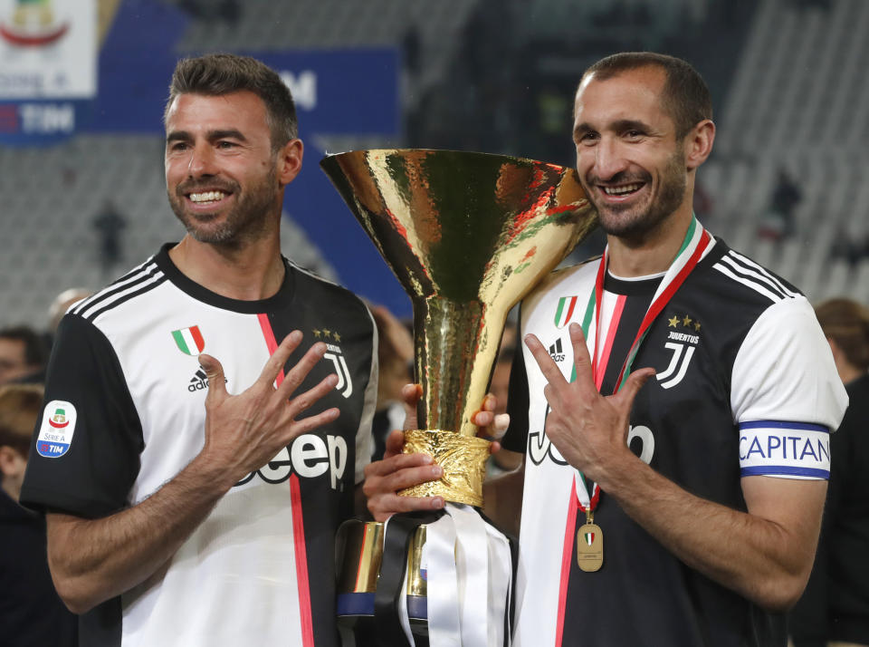 Andrea Barzagli (izquierda) y Giorgio Chiellini de la Juventus posan tras obtener el trofeo de la Serie A italiana, en Turín, Italia, el domingo 19 de mayo de 2019. (AP Foto/Antonio Calanni)