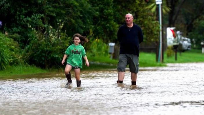 Dos personas caminan por un camino inundado en Nueva Zelanda