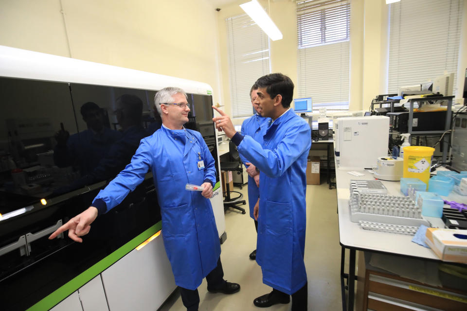 hBritain's Chancellor of the Exchequer Rishi Sunak (C) gestures as he speaks to staff members during a visit to the pathology labs at Leeds General Infirmary to highlight the record infrastructure spend after yesterday's budget, in Leeds, Yorkshire on March 12, 2020. (Photo by Danny Lawson / POOL / AFP) (Photo by DANNY LAWSON/POOL/AFP via Getty Images)