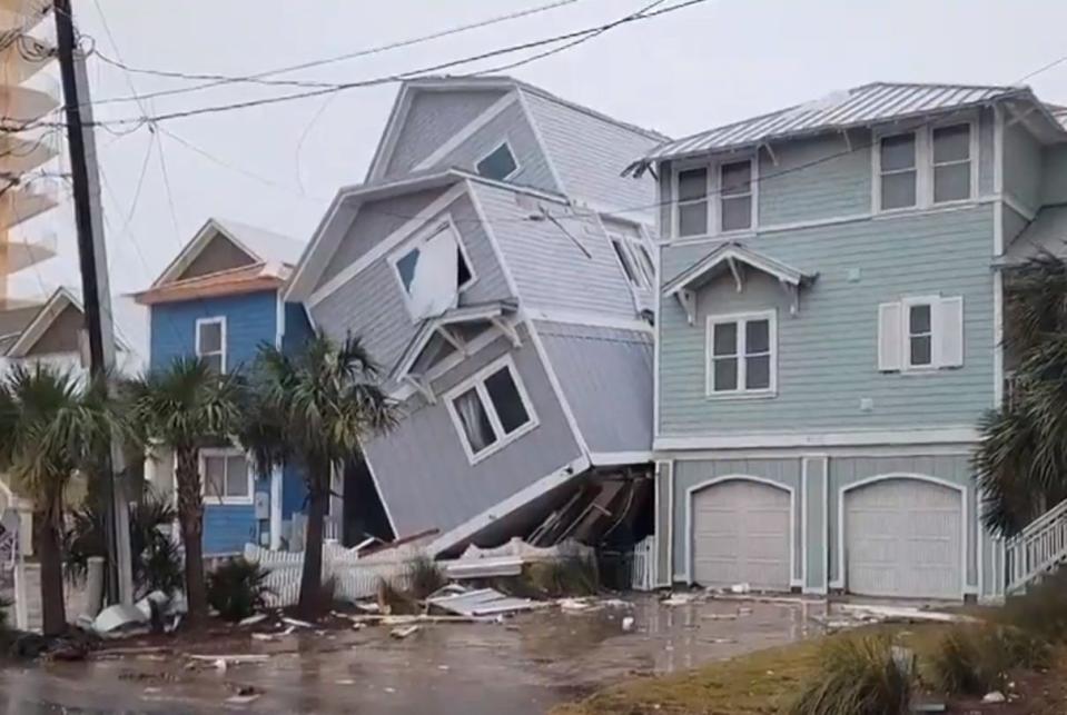 An early morning tornado Tuesday, Jan,. 9, 2024, left a two-story Panama City house tilted and leaning against the neighbor's building.